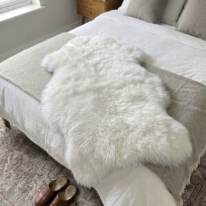Großes weißes Schaffell für das Bett