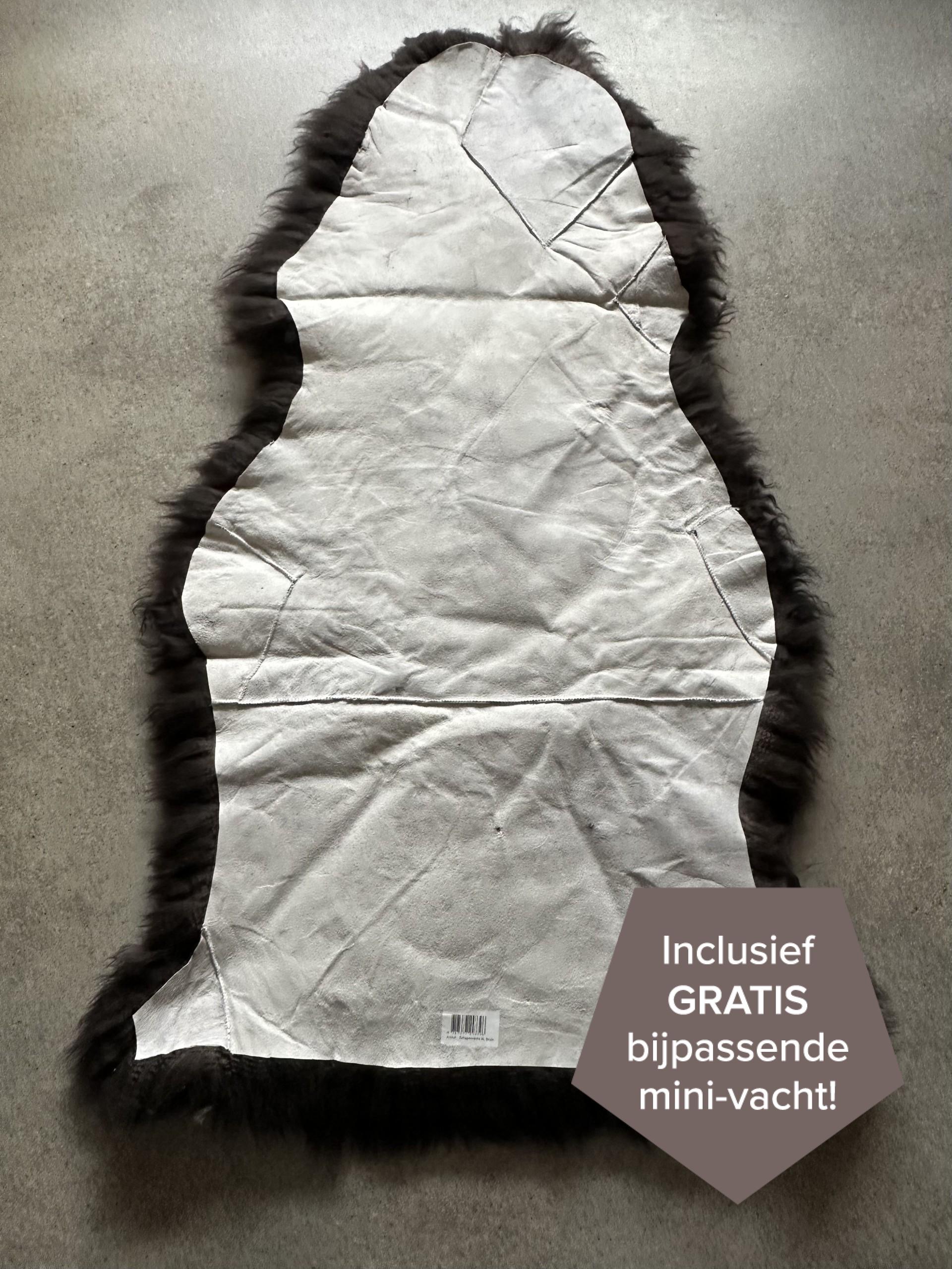 Dunkelbrauner XXL Patchwork Schaffellteppich Rückseite auf grauem Boden